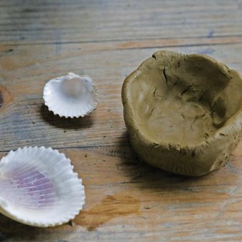 Abdrücke mit Muscheln in Tonschälchen beim Kindertöpfern